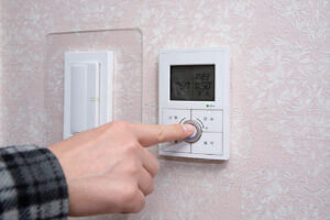 inspecting the thermostat during a fall furnace tuneup